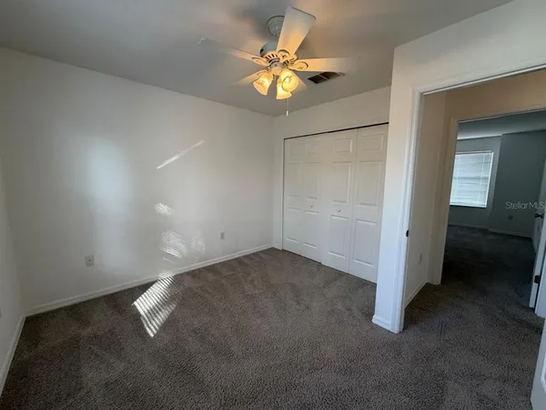 en empty room with closet and a ceiling fan