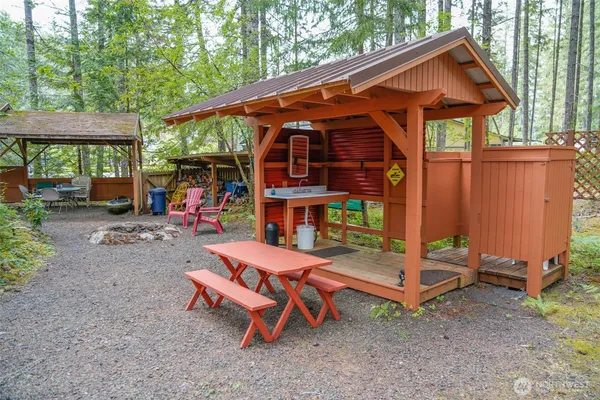 a backyard of a house with barbeque oven table and chairs