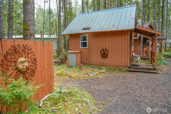 a view of a small house with yard and a tree