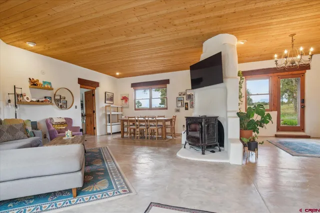 a living room with furniture a flat screen tv and a floor to ceiling window