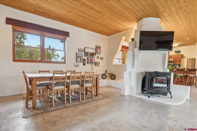 a dining room with furniture and a flat screen tv