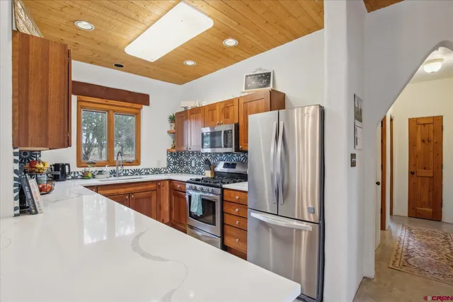 a kitchen with stainless steel appliances granite countertop a refrigerator and a sink