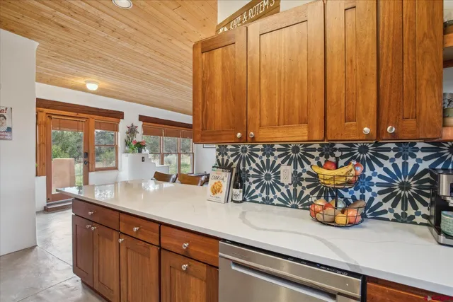 a kitchen with stainless steel appliances granite countertop a sink a stove and a wooden cabinets