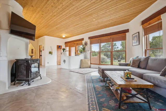 a living room with furniture a flat screen tv and a floor to ceiling window