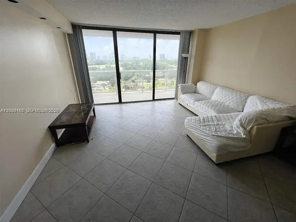 a living room with furniture and a floor to ceiling window