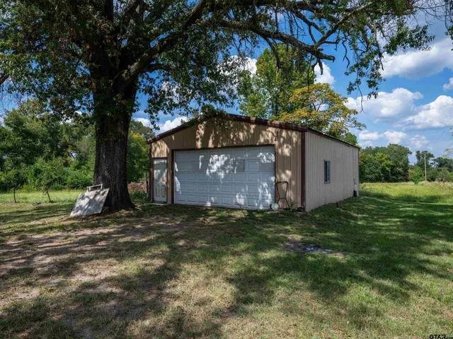 a view of a yard with an tree and a fence