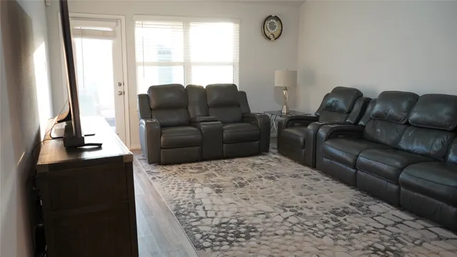 a living room with furniture window and a flat screen tv