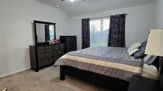 a bed sitting in a bedroom next to a window with dresser