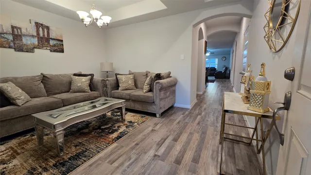 a living room with furniture a table and wooden floor