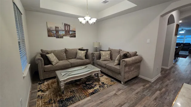 a living room with furniture and a chandelier