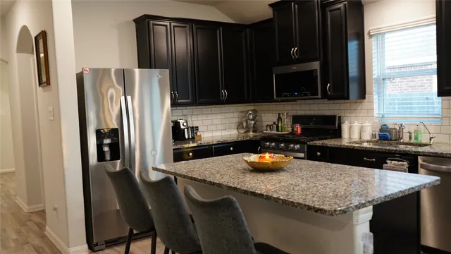 a kitchen with a sink a counter and chairs