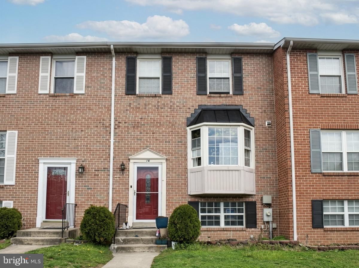 a front view of a house with a yard and plants