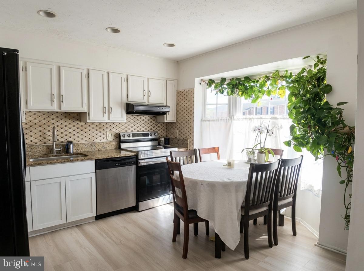 16 Powhurst Court Baltimore, MD 21236 - Photo 7 of 22 a kitchen with granite countertop white cabinets dining table and chairs