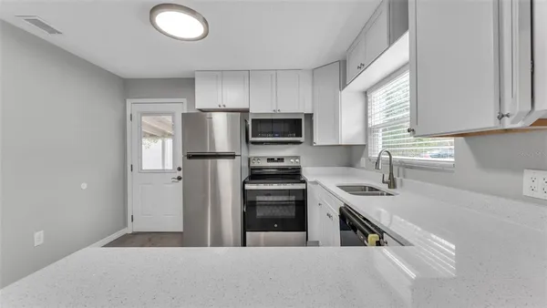 a kitchen with stainless steel appliances granite countertop a stove a sink and a refrigerator