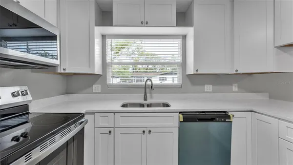 a kitchen with stainless steel appliances granite countertop a sink stove and white cabinets