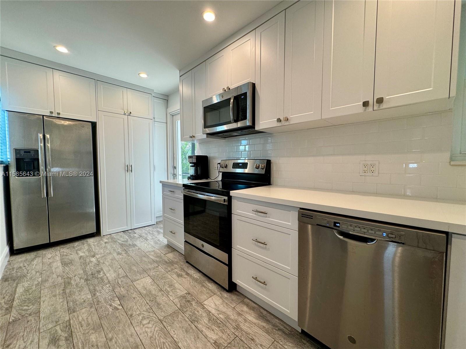 4235 Southwest 14th Street Miami, FL 33134 - Photo 12 of 32 a kitchen with granite countertop a refrigerator stove and microwave