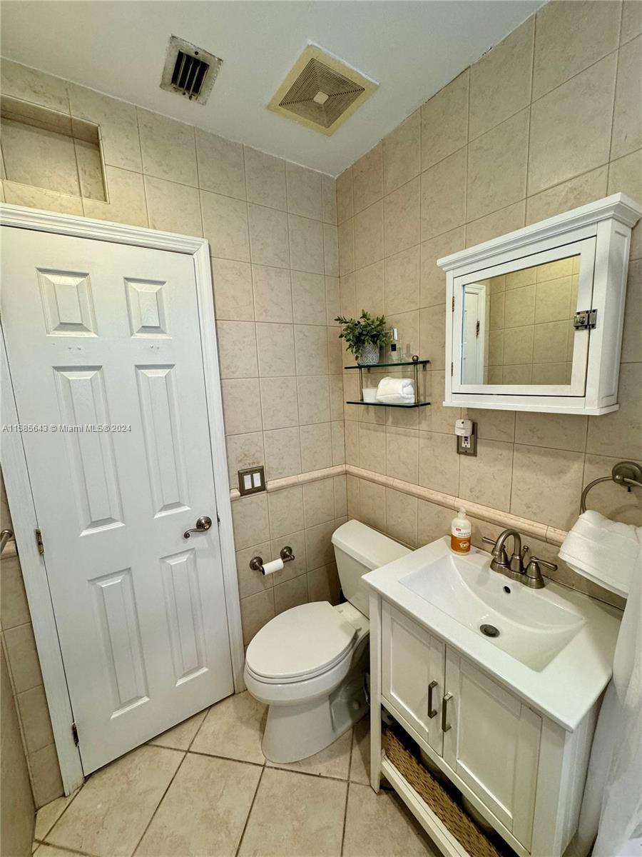 4235 Southwest 14th Street Miami, FL 33134 - Photo 22 of 32 a bathroom with a sink mirror vanity and toilet