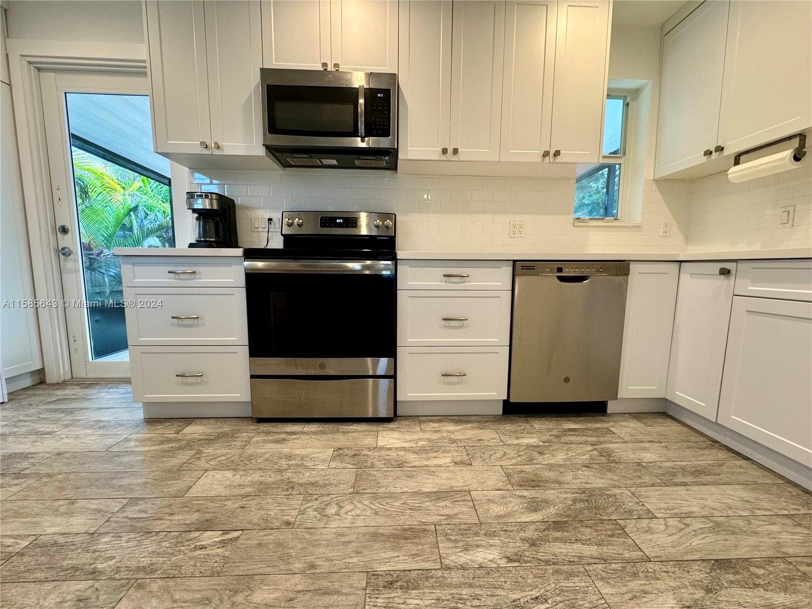 4235 Southwest 14th Street Miami, FL 33134 - Photo 3 of 32 a kitchen with granite countertop a stove microwave and a sink