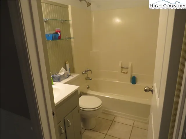 a bathroom with a granite countertop bathtub shower sink vanity and toilet