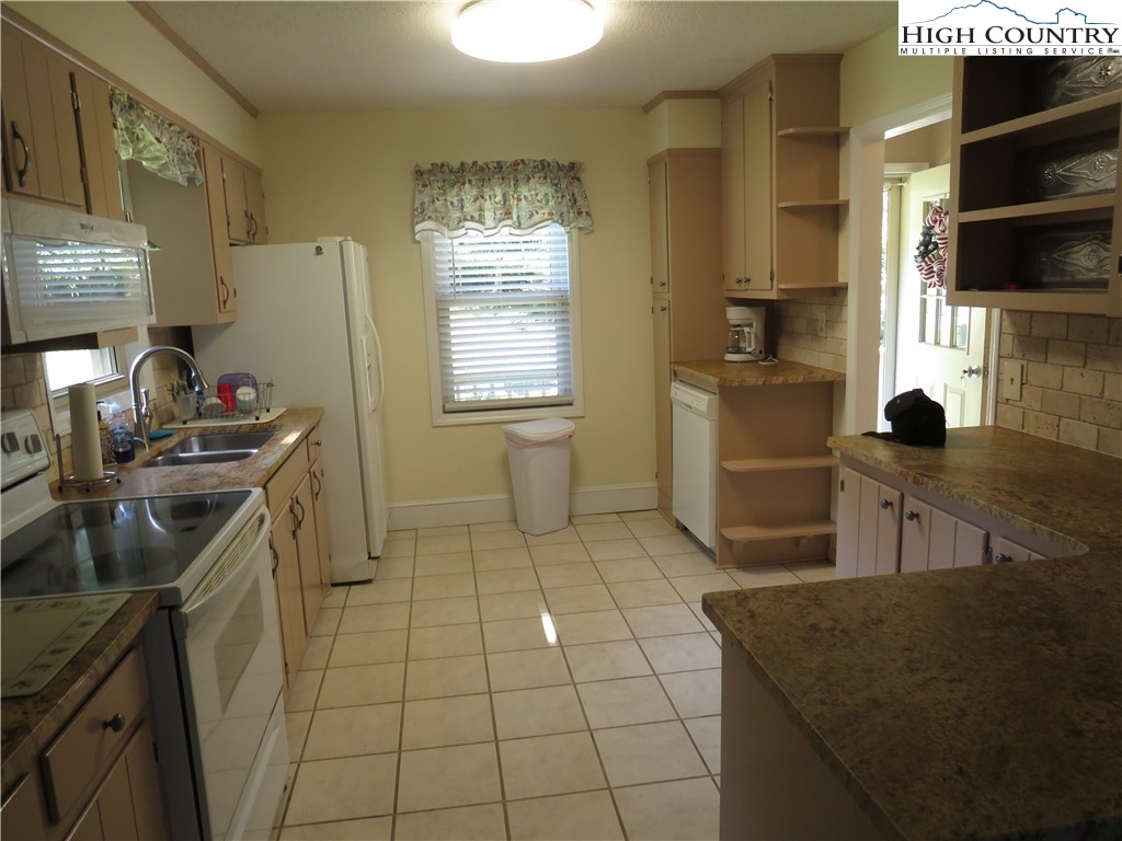 296 Silo Road Sparta, NC 28675 - Photo 4 of 24 a kitchen with a sink a stove and a refrigerator