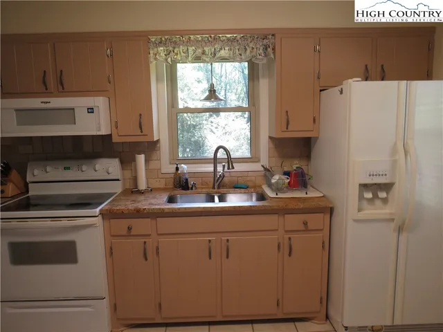 a kitchen with white cabinets and white appliances