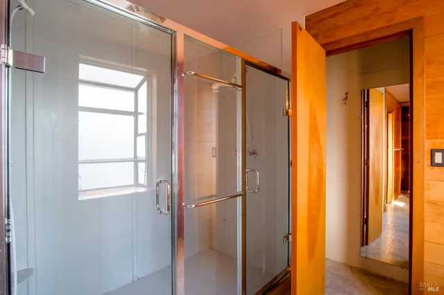 a bathroom with a glass door shower and a sink