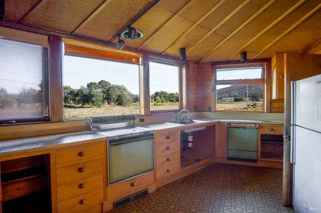a kitchen with sink a window and refrigerator