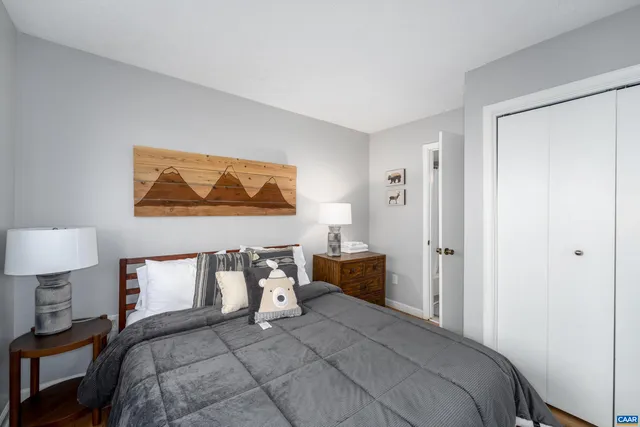 a bedroom with a bed and a lamp on dresser