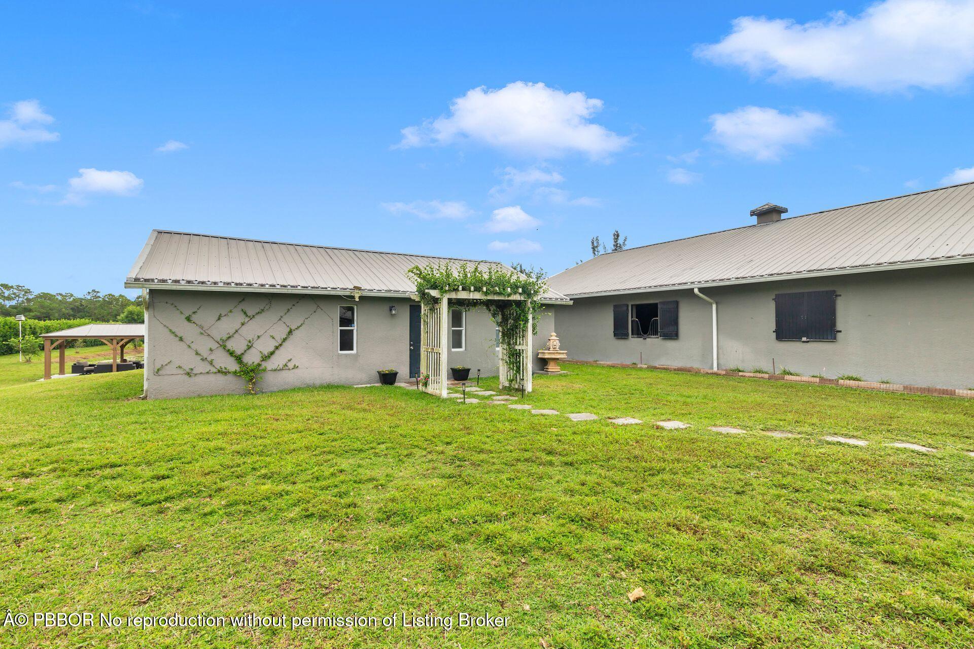 2770 E Road Loxahatchee, FL 33470 - Photo 19 of 51 a front view of a house with a garden