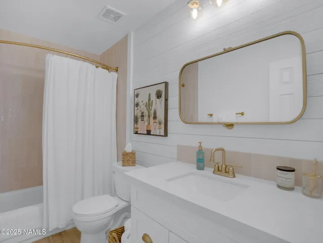 a bathroom with a sink a toilet and mirror