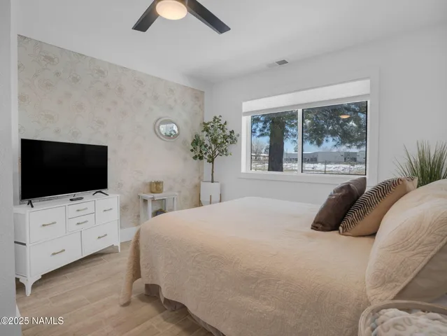 a bedroom with a bed and a flat screen tv