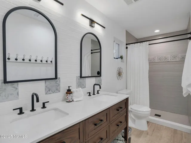 a bathroom with a double vanity sink toilet and shower