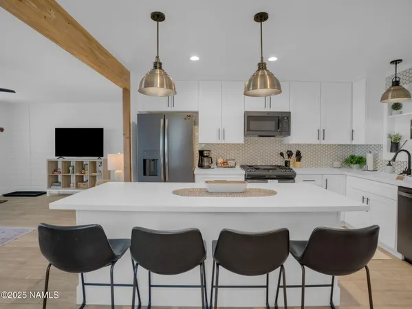 a kitchen with stainless steel appliances a dining table chairs and granite counter tops