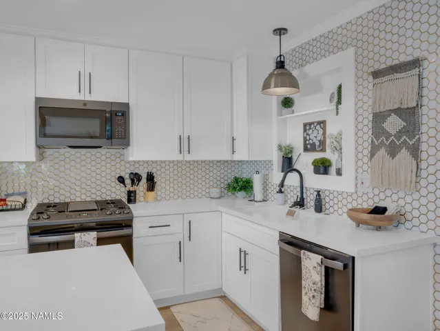 a kitchen with white cabinets and stainless steel appliances