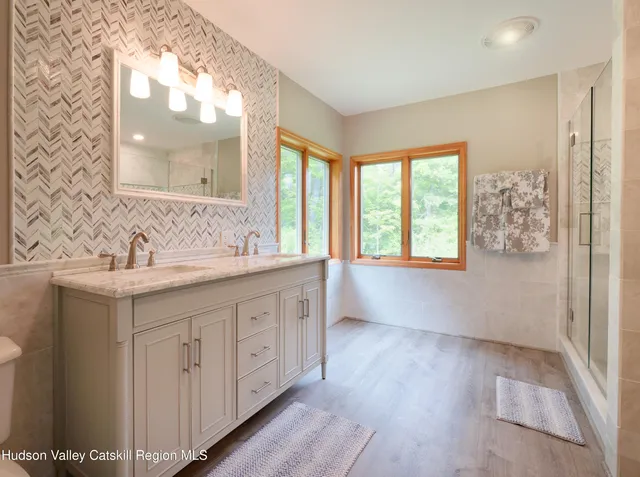 a bathroom with a sink mirror and a window