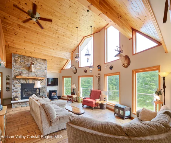 a living room with furniture a large window and a fireplace