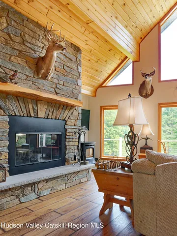 a living room with fireplace furniture and a large window