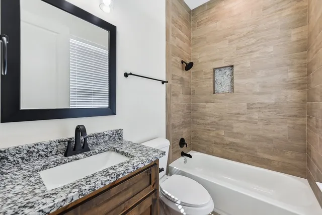 an empty room with wooden floor a ceiling fan and staircase