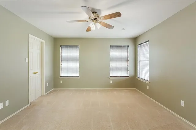 a view of room with a ceiling fan and window