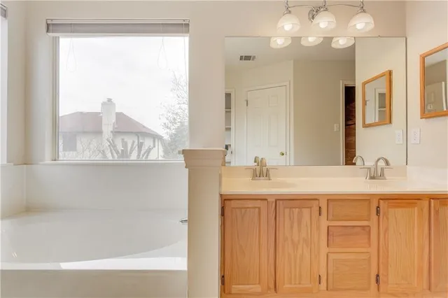 a bathroom with a granite countertop sink and a large mirror