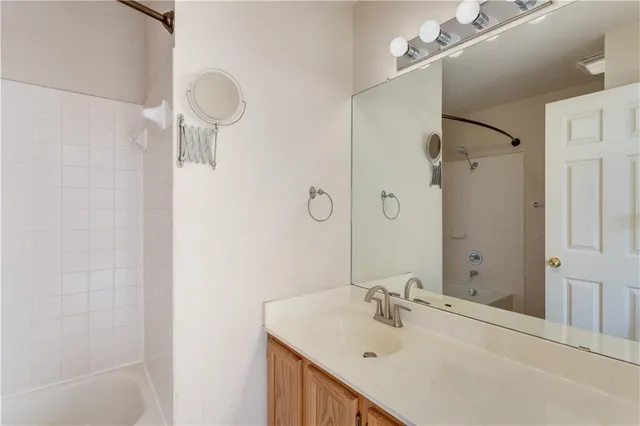 a bathroom with a sink vanity tub and shower