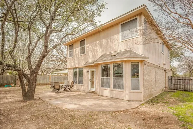 a view of a white house with large trees and a big yard