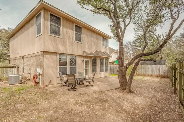 a backyard of a house with table and chairs