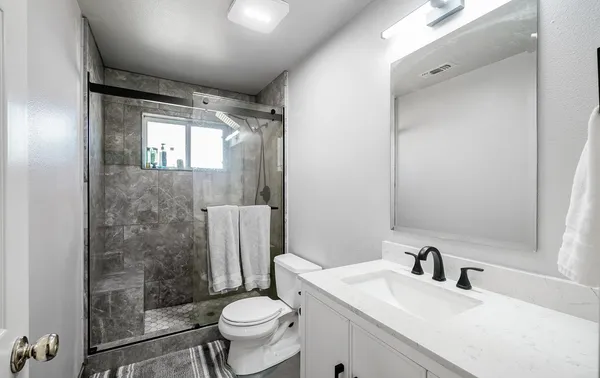 a view of an empty room with a fireplace and a window