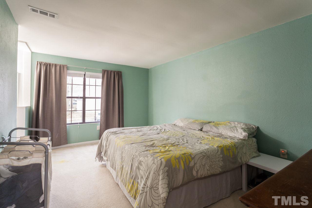 7900 Falcon Rest Circle, Unit 10 Raleigh, NC 27615 - Photo 17 of 25 a bed sitting in a bedroom next to a window