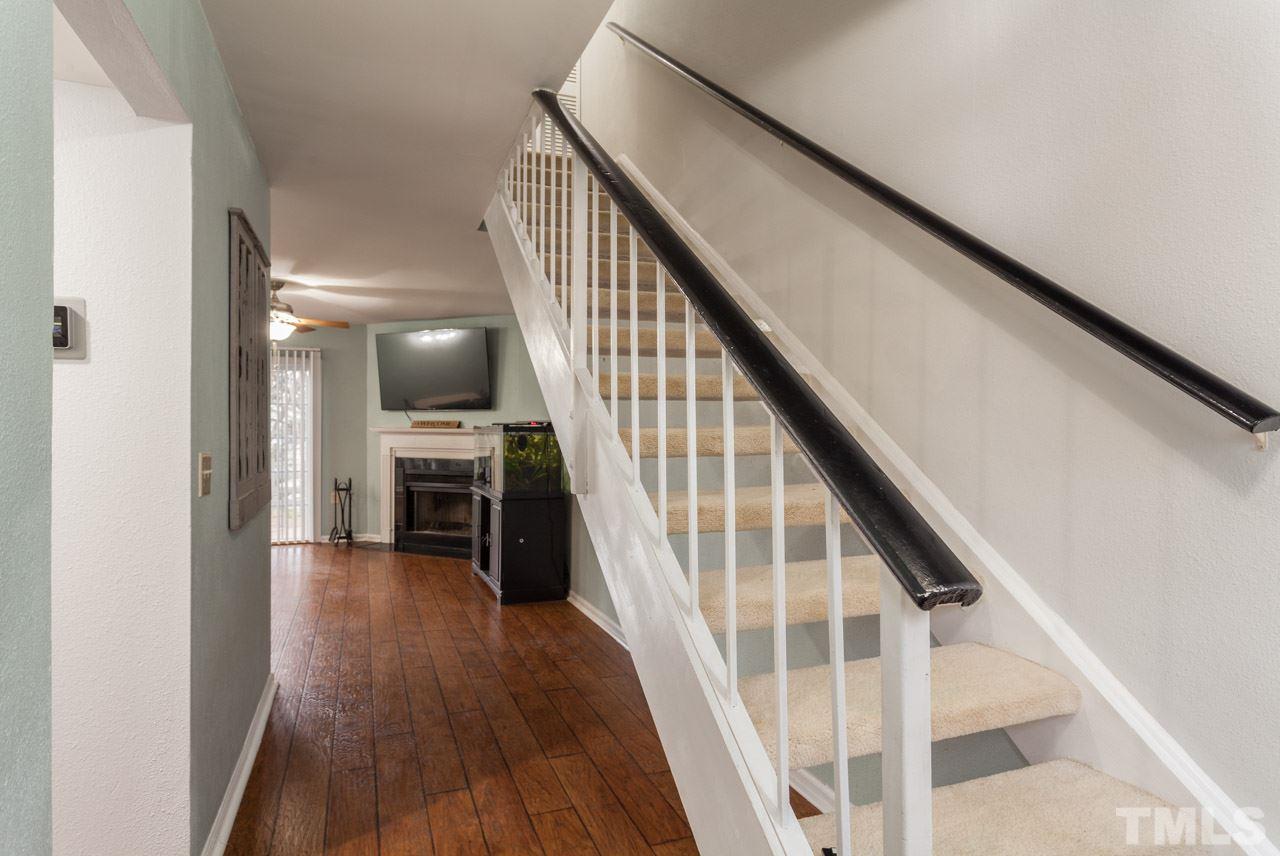 7900 Falcon Rest Circle, Unit 10 Raleigh, NC 27615 - Photo 5 of 25 a view of a hallway with wooden floor staircase and kitchen view
