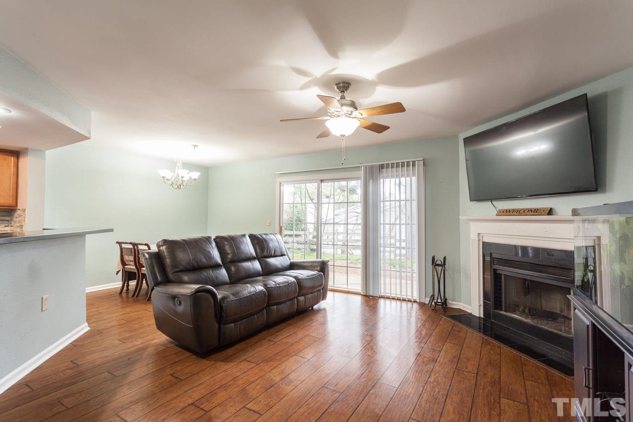 7900 Falcon Rest Circle, Unit 10 Raleigh, NC 27615 - Photo 8 of 25 a living room with furniture a fireplace and a flat screen tv