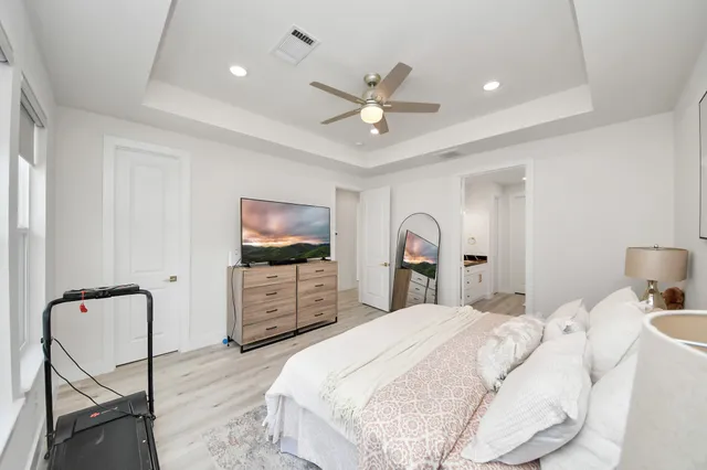 a bedroom with a bed and a flat screen tv on dresser
