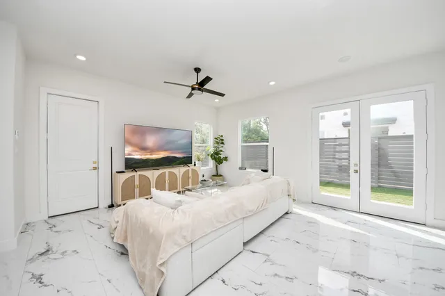 a bedroom with a large bed and a flat tv screen