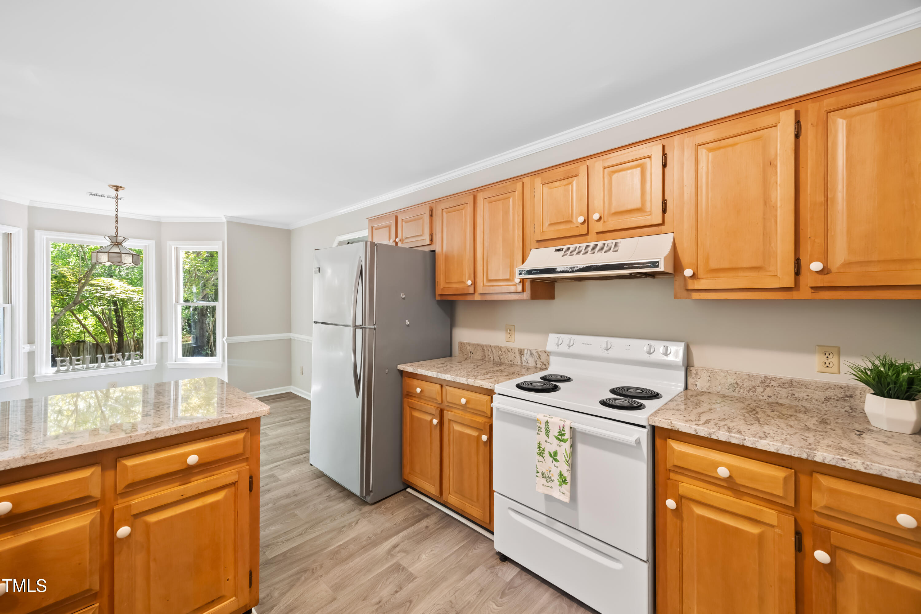 3421 East Jameson Road Raleigh, NC 27604 - Photo 8 of 25 a kitchen with stainless steel appliances granite countertop wooden cabinets stove top oven and sink